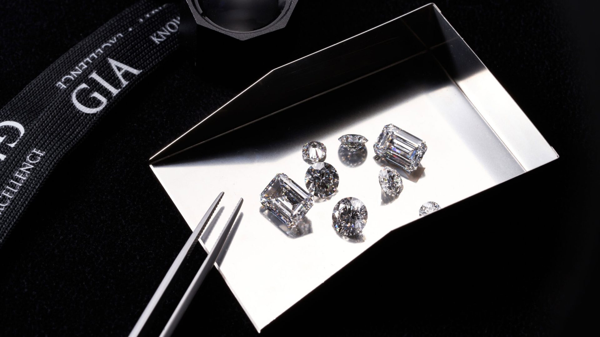 ALT：閃亮的培育鑽石與求婚戒指展示於黑色背景.